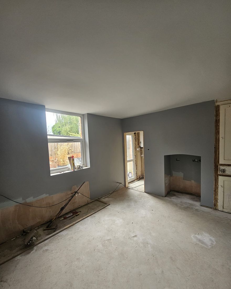 The same wall of the kitchen-diner with a new flat ceiling, plastered and painted walls and a screeded floor
