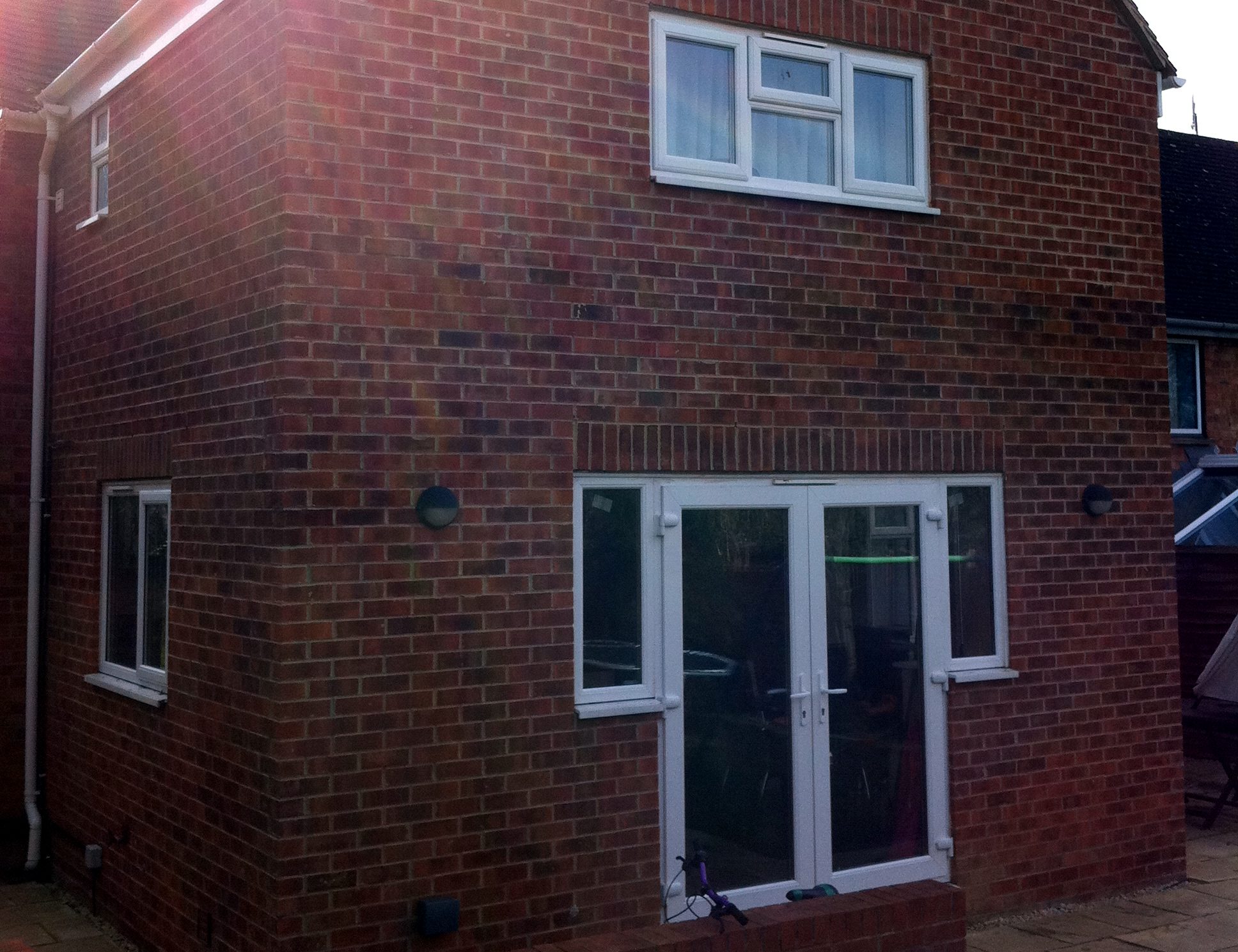 Finished two-storey brick rear extension by JonesBuild, with French doors on the ground floor and a window above
