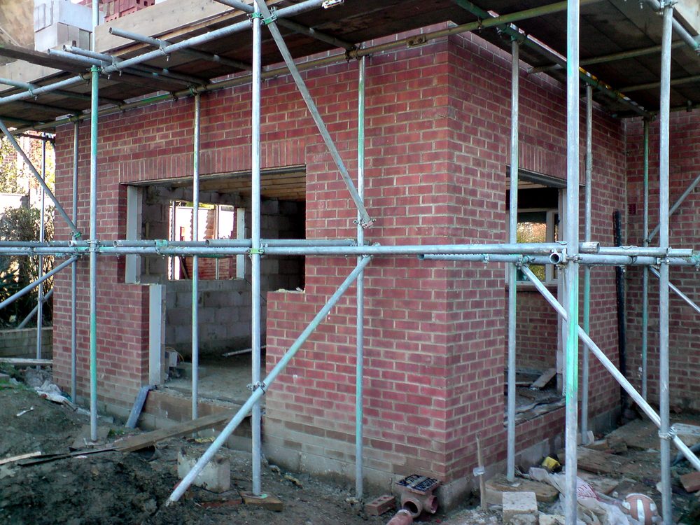 Two-storey brick extension shell under scaffolding