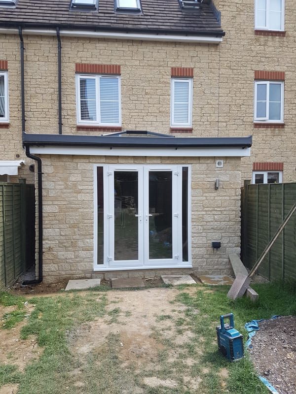Stone-faced single-storey rear extension with roof lantern and French doors