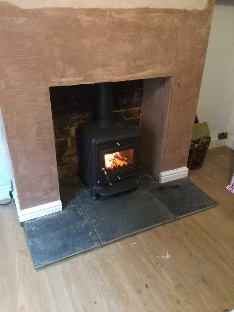 Re-plastered chimney breast with log burner fitted on a slate hearth