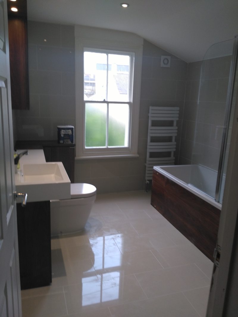 Modern bathroom with large-format tiles and wall-hung vanity