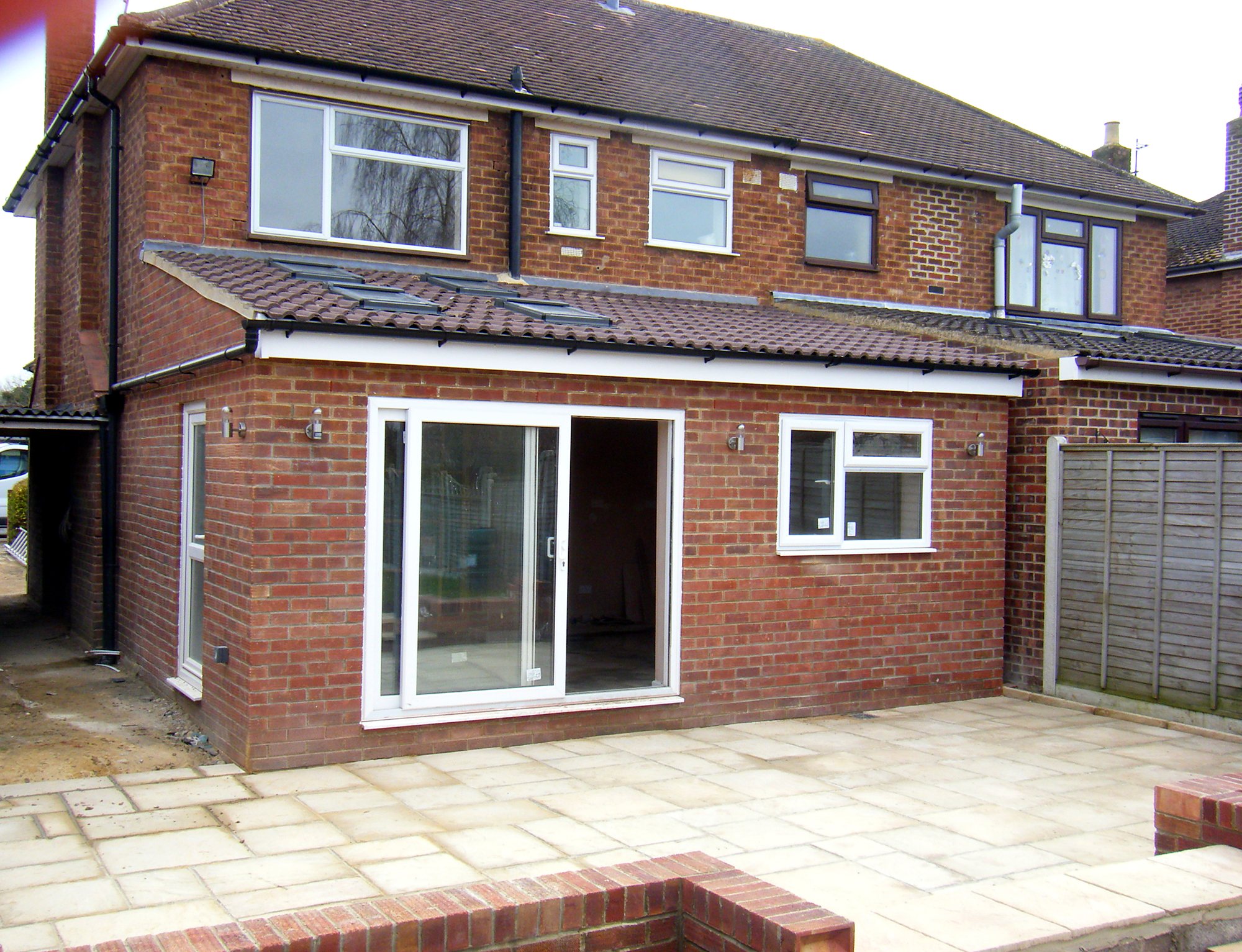 Finished single-storey rear extension by JonesBuild in Gloucestershire, with sliding doors, rooflights and a new patio