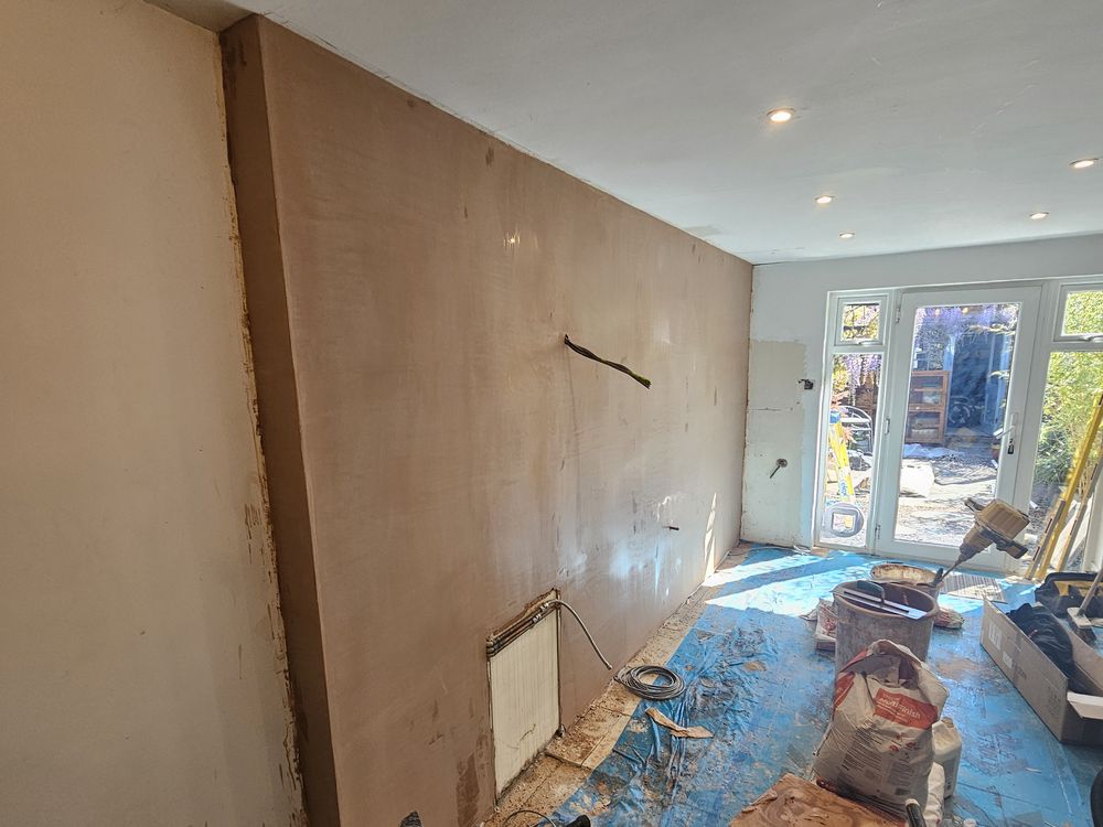 Long kitchen walls freshly skimmed, looking towards the French doors, floor protected