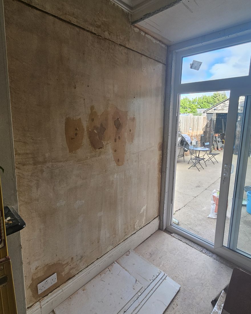 Rear-room wall prepared for skimming beside new white French doors