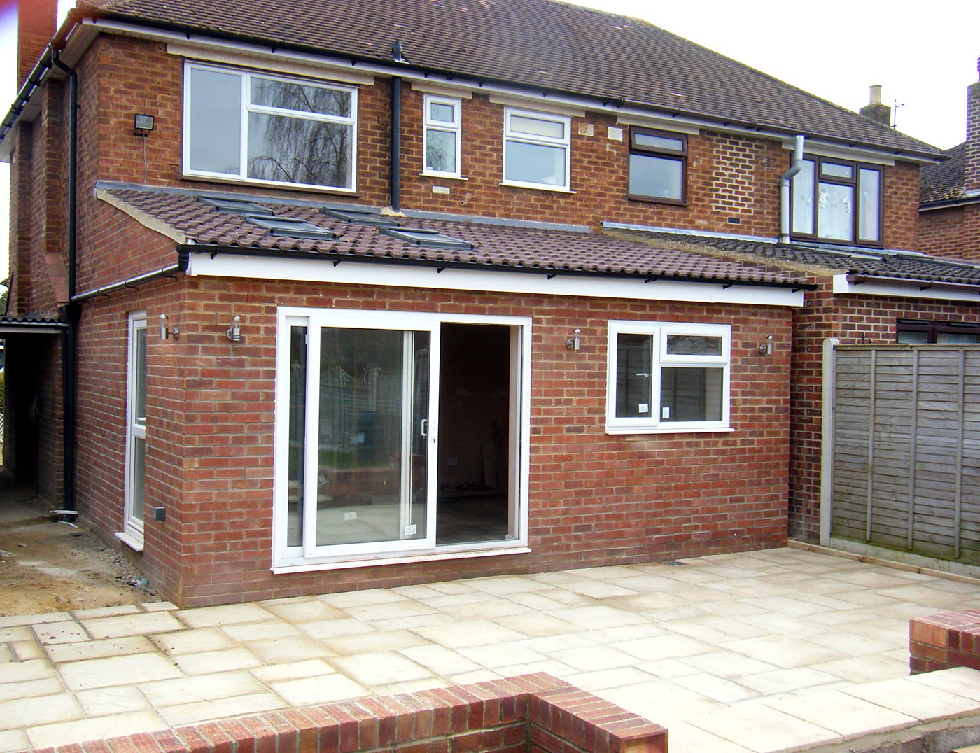 Finished single-storey rear extension with sliding doors, rooflights and new patio