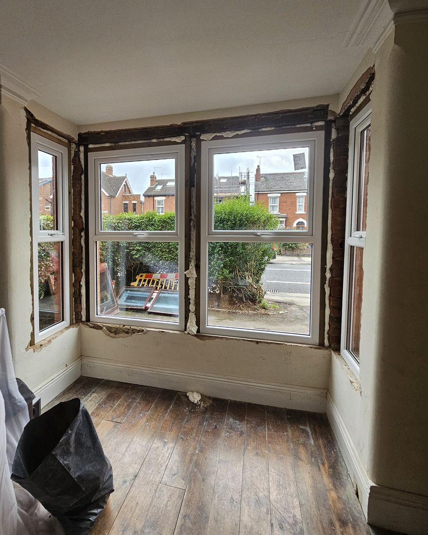 Front-room bay with new white windows fitted and bare floorboards